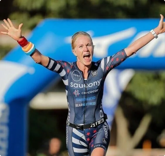 Athlete celebrating at a triathlon finish line