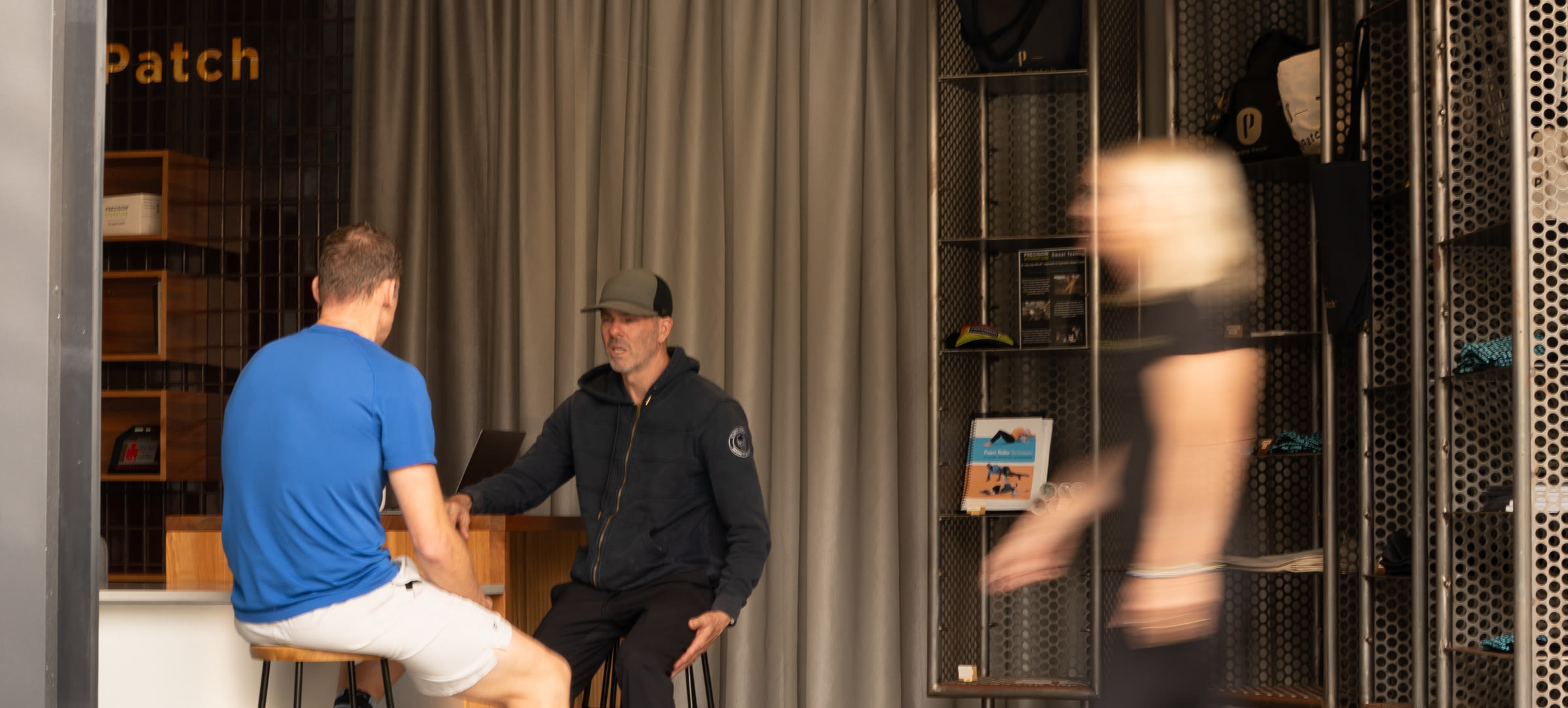 A coach and an athlete talking at the Center’s front counter