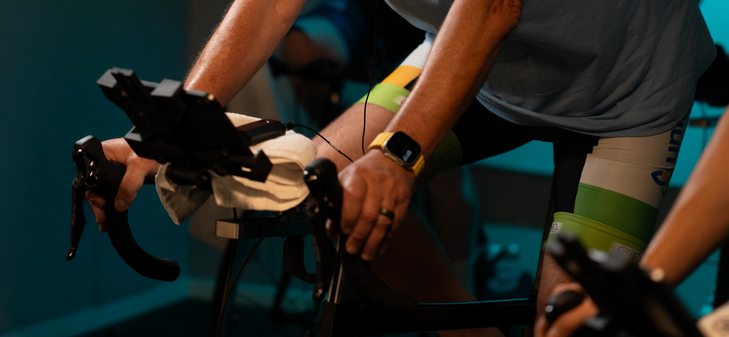 Rider’s hands on the bars in the Purple Patch bike studio
